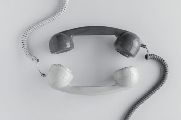 Twee bellers worden met elkaar in contact gebracht doordat twee retro telefoonhoorns naast elkaar zijn gelegd. een simpele oplossing.
